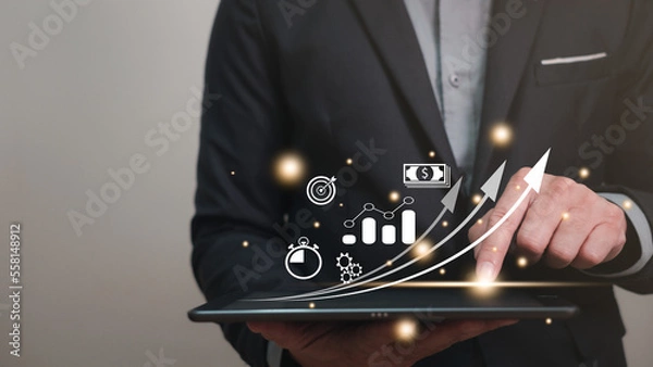 Fototapeta start up business planning concept, business man wearing suit using tablet for planning his start up business for good management and progress