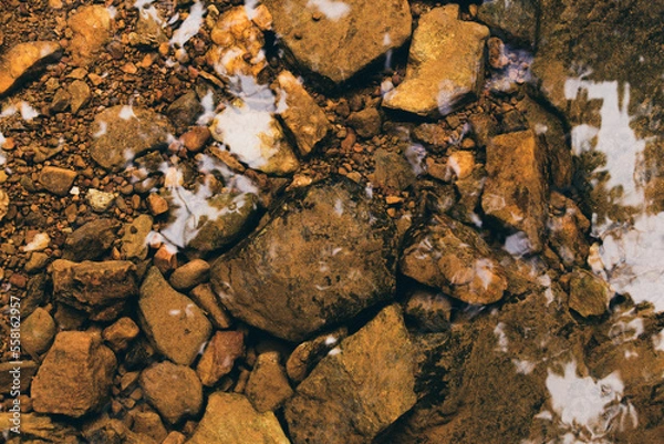 Obraz Background of clear river water with mossy rocks at the bottom.
