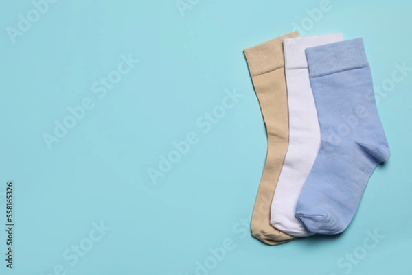 Fototapeta Different socks on light blue background, flat lay. Space for text