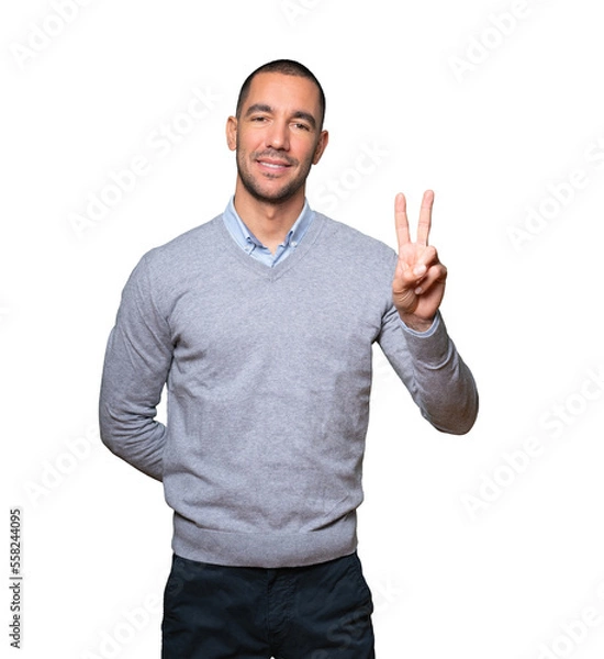Fototapeta Young man making a number two gesture