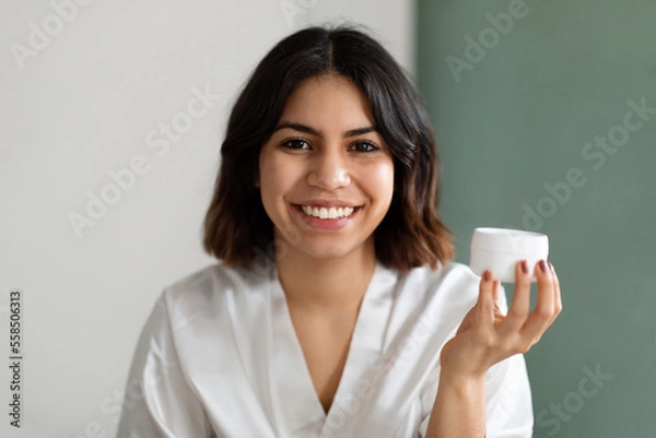 Fototapeta Headshot of beautiful woman using new cosmetic at home