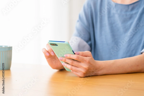 Fototapeta 車椅子に座りながらスマートフォンを操作する若い女性　多様性社会イメージ