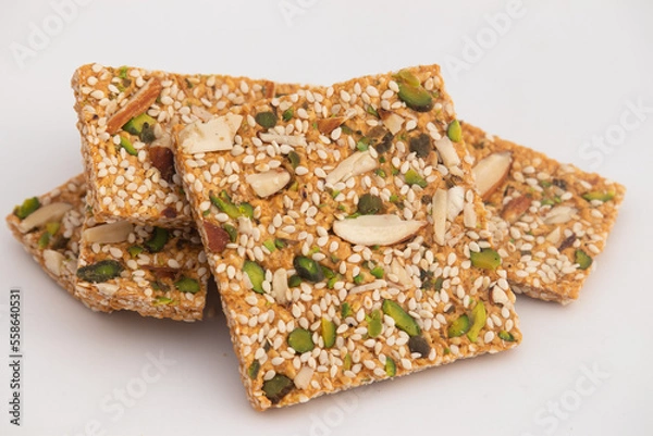 Fototapeta Pista Badam Gajak Patti Or Tilgul Papdi Chikki Gazak Or Gachak Bar Made Of Crushed Sesame Seeds, Roasted In Ghee With Jaggery, Gur, Almonds, Kaju, Gud Is Enjoyed In Winter On Makar Sankranti And Lohri