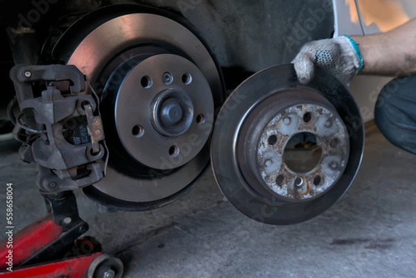 Fototapeta Replacing brake discs on a car. Removed the old brake disc from the car and installed the new brake disc. Car maintenance