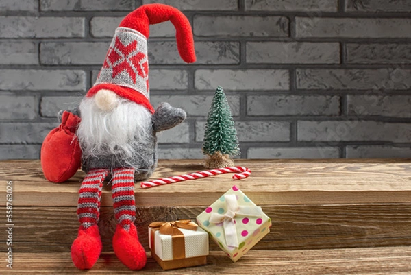 Obraz Cute Christmas gnome and festive decor on table. Space for text