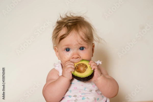 Obraz Little child eats an avocado