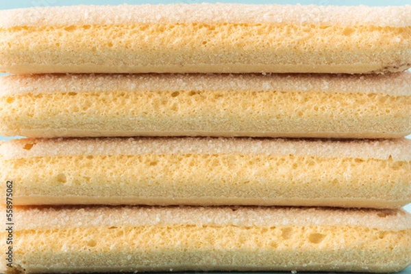 Fototapeta Traditional Italian savoiardi ladyfinger cookies stacked together as a textured background. Macro shot of sweet sponge biscuits for tiramisu cake.