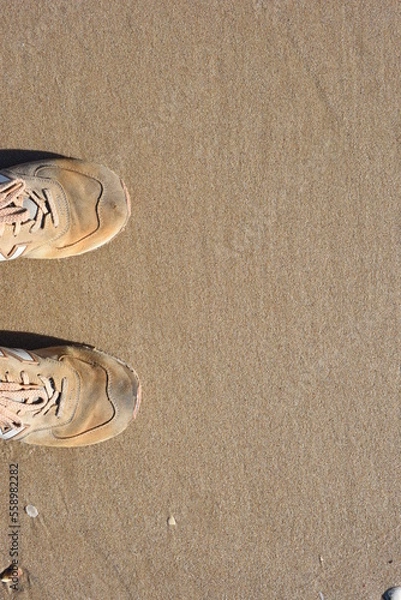 Fototapeta Background created from the sand on the beach with the sneakers.