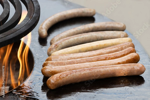 Fototapeta Cooking sausage, summer picnic in backyard. Healthy and fastfood concept. Barbecue grill, fire, flame.