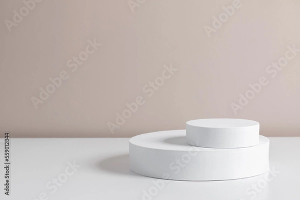 Fototapeta White round pedestal podium mockup on beige background. Front view. Place for text, copy space, mockup