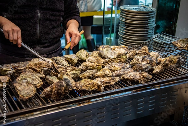 Fototapeta the closeup image of grilled oyster provided by local restaurant in Itsukushima， part of the city of Hatsukaichi in Hiroshima Prefecture Japan.  Oyster is popular and famous local food. 