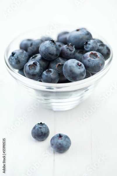 Fototapeta Glass dish with freshly picked blueberries, vertical shot