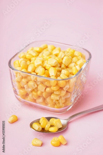 Obraz Bowl with canned corn kernels and spoon on pink background