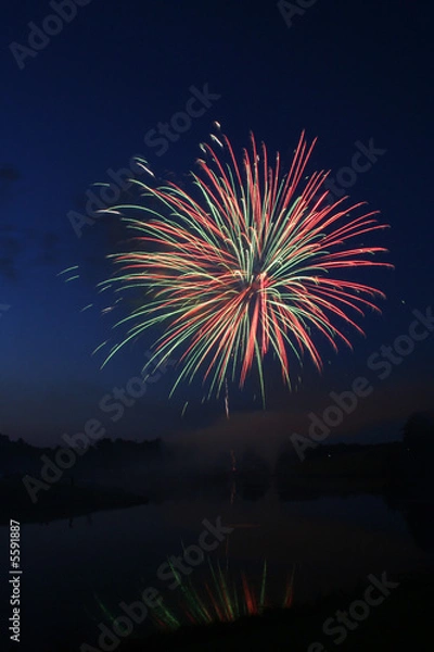 Fototapeta Fireworks display in front of a lake.