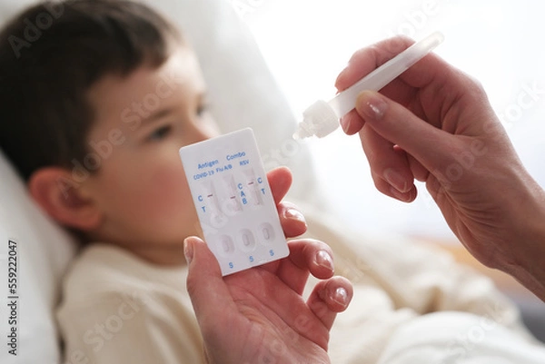 Fototapeta A little boy is sick, a combo antigen test (covid-19, flu a b, RSV) is needed for proper diagnosis.