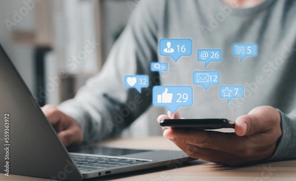 Fototapeta Social media marketing concept on mobile phone with notification icons of like, message, comment and star above smartphone screen.