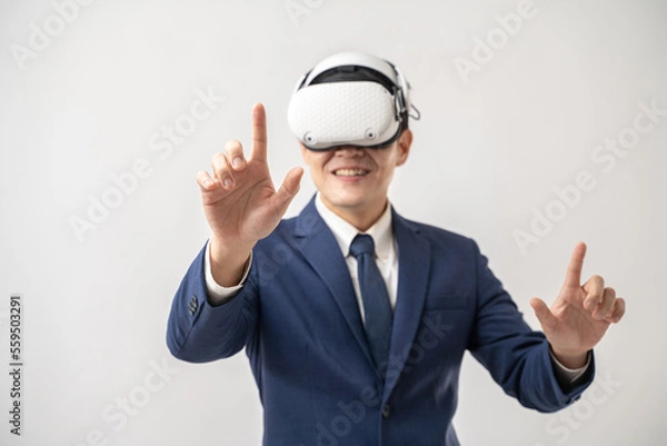 Fototapeta Portrait of confident Asian businessman using VR virtual reality headset isolated on white background