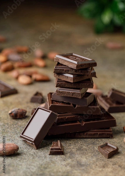 Obraz Broken chocolate pieces on dark background. Stack of dark chocolate. Chocolate concept