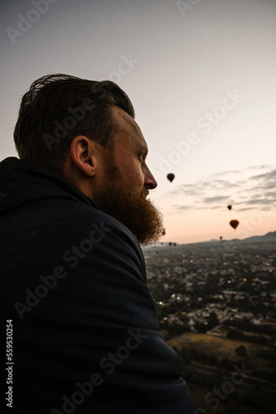 Fototapeta Man looking out over Mexico City and Pyramids riding in a hot air baloon