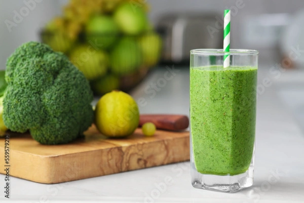 Fototapeta Glass of delicious smoothie and ingredients on white table in kitchen