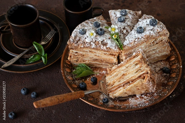 Fototapeta Cake "Napoleon" from puff pastry, decorated with blueberries and flowers.