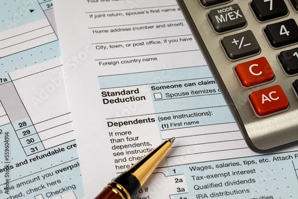Fototapeta Standard deduction on federal income tax return forms and calculator. Federal tax return, income tax and tax refund concept