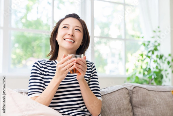 Fototapeta 部屋でリラックスする若い女性　飲み物