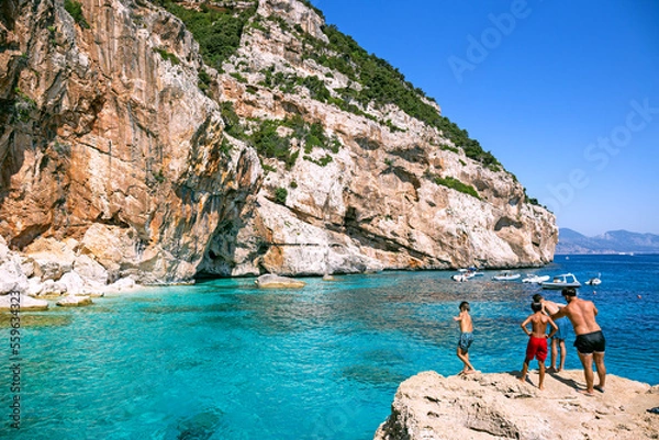 Obraz People jumping from the cliff into turquoise waters of Cala Mariolu, Sardinia, Italy