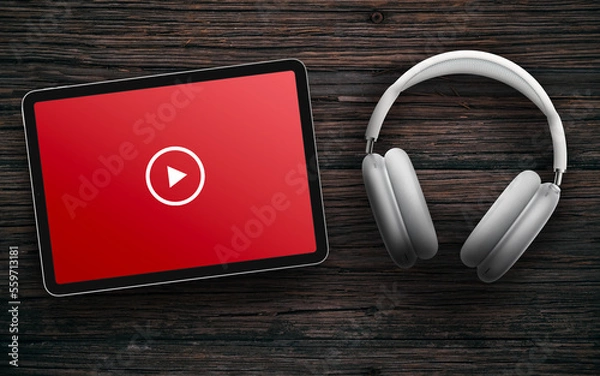Obraz Play button on red screen of tablet and wireless headphones on dark wooden surface. Online streaming with white headset