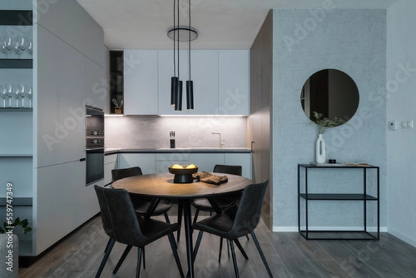 Fototapeta Kitchen with built in appliances and dining table of modern apartment
