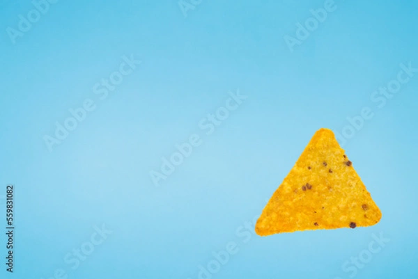Obraz nachos chips isolated on blue background. falling down doritos triangle