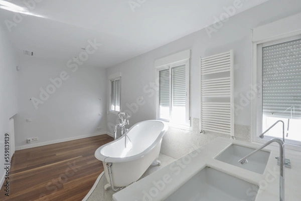 Fototapeta Bathroom with a wall covered in gresite-type tile, a two-bowl white marble sink and a bathtub on the surface with legs