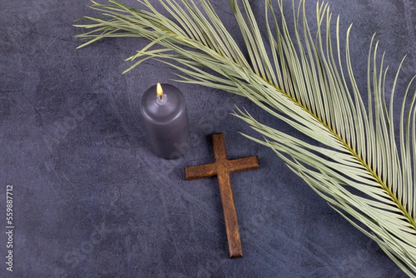 Fototapeta Catholic Cross with palm leaf and burning candle. Ash Wednesday, Lent season, Holy Week, Good Friday and Palm Sunday concept.