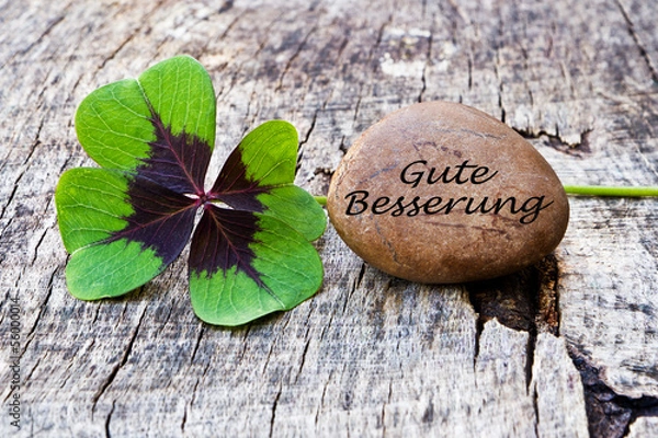 Fototapeta vierblättriges Kleeblatt mit Stein auf Holz, Gute Besserung