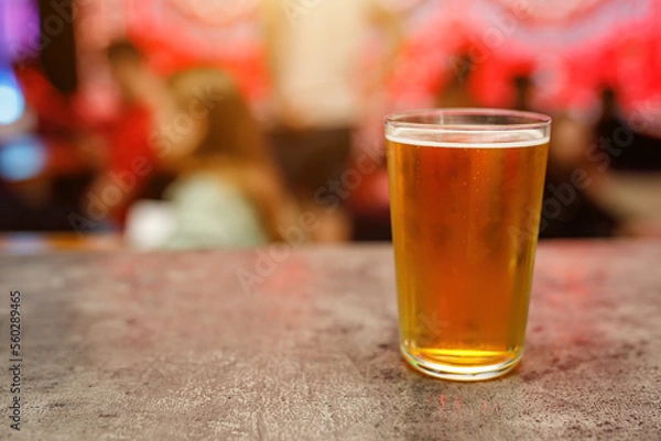 Fototapeta A glass of cold draft beer in a pub.