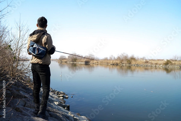 Obraz 真冬の川でバス釣りをする男性