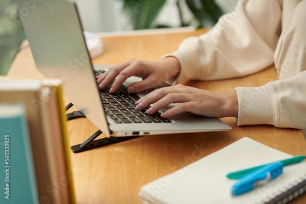 Obraz Closeup image of woman working on laptop, answering e-mails or filling documents