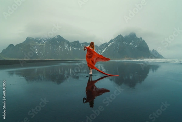 Obraz Model in elegant gown on Reynisfjara beach scenic photography. Picture of person with mountains on background. High quality wallpaper. Photo concept for ads, travel blog, magazine, article