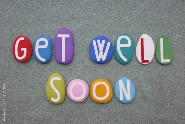 Fototapeta Get well soon, creative message composed with multi colored stone letters over green sand