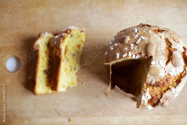 Fototapeta Traditional italian Panettone, typical Christmas cake, on a chopping board with two slices ready to be tasted.