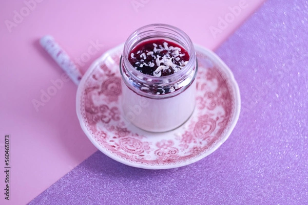 Obraz Summer dessert - delicious Italian pannacotta with coconut milk and red berries jam on a pink board