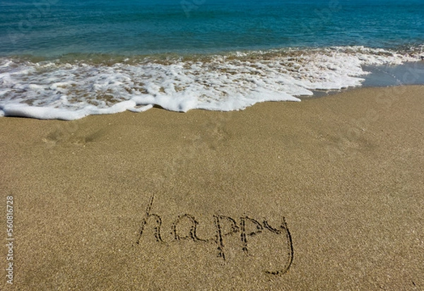 Fototapeta Happy is written on the sand. Message in the sand. Soft focus. 