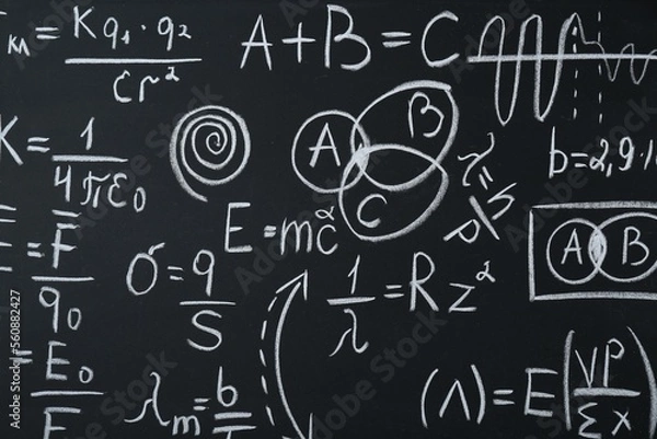 Fototapeta Different physical formulas written with chalk on blackboard, closeup