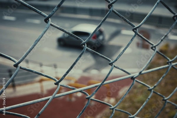 Obraz 철조망 밖의 흐린 풍경으로 지나가는 자동차