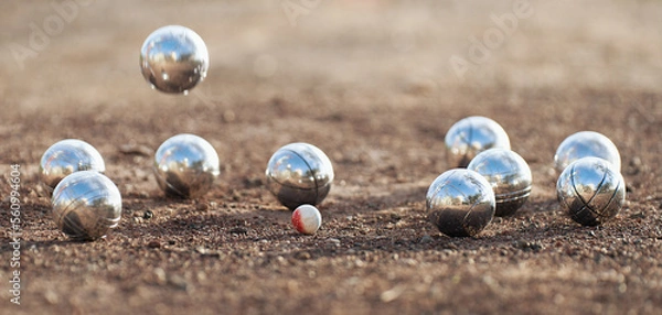 Fototapeta Petanque ball boules bowls on a dust floor, photo in impact. Game of petanque on the ground. Balls and a small wood jack
