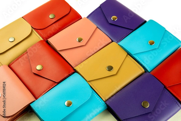 Fototapeta bright colored leather wallets lie tightly to each other. close-up on a white background