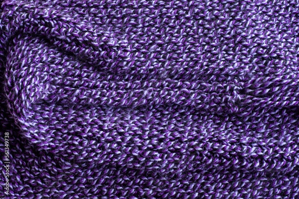 Fototapeta Knitted warm purple sweater or scarf handmade. Cozy composition in the home atmosphere. Wool fabric texture close up background. Comfortable style cloth. Wavy folds material.