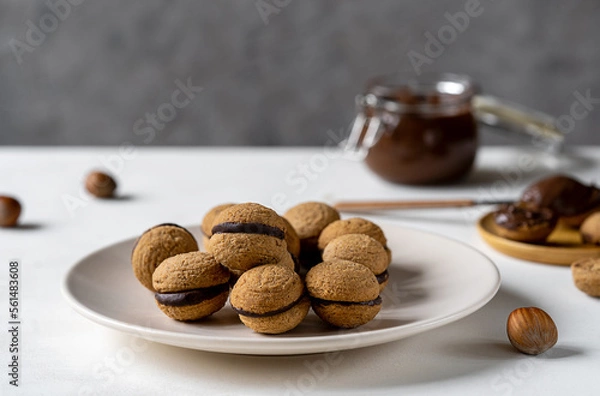 Fototapeta Hazelnut biscuits baci di dama or lady's kisses are traditional Italian dessert made as a sandwich with two cookies and chocolate cream. 