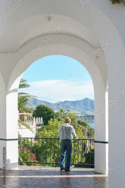 Fototapeta An unidentified person stands at an arched lookout over the Mediterranean Sea on a sunny day in in Nerja, Spain.  Image has copy space.
