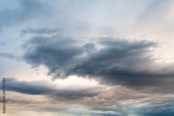 Fototapeta Cloudscape of grey bluish clouds in a stormy golden sky